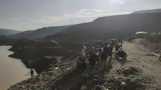 Miners, rescuers and local residents look at the jade mine site where a landslide accident took place in Hpakant township, Kachin state, Myanmar Sunday, Aug. 13, 2023. A landslide at the jade mine left scores of people missing, and a search and rescue operation was underway on Monday, a rescue official said. (AP Photo)