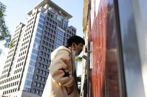 A man gets swabbed for COVID test near a building of the Peking University in Beijing, Wednesday, Nov. 16, 2022. Chinese authorities locked down the major university in Beijing on Wednesday after finding one COVID-19 case as they stick to a "zero-COVID" approach despite growing public discontent. (AP Photo/Ng Han Guan)