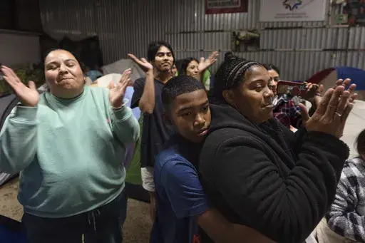 Margelis Rodriguez, right, of Venezuela, gets a hug from her son Mickel during a birthday party at a shelter for migrants in Tijuana, Mexico, Wednesday, Feb. 5, 2025. (AP Photo/Gregory Bull)