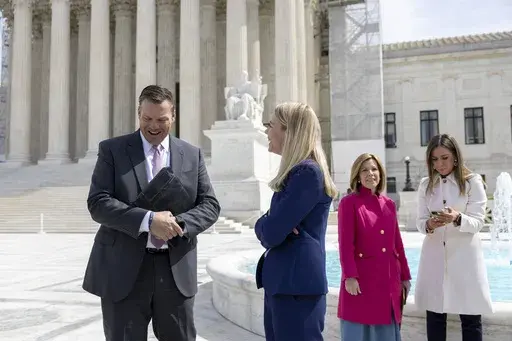 Kansas Attorney General Kris Kobach, left, and Erin Hawley, Alliance Defending Freedom Senior Counsel, speak to each other outside the Supreme Court after the Court heard oral arguments, Tuesday, March 26, 2024, in Washington. Kansas’ highest court on Friday, July 5, 2024, struck down state laws regulating abortion providers more strictly than other health care providers and banning a common second-trimester procedure, reaffirming its stance that the state constitution protects abortion access