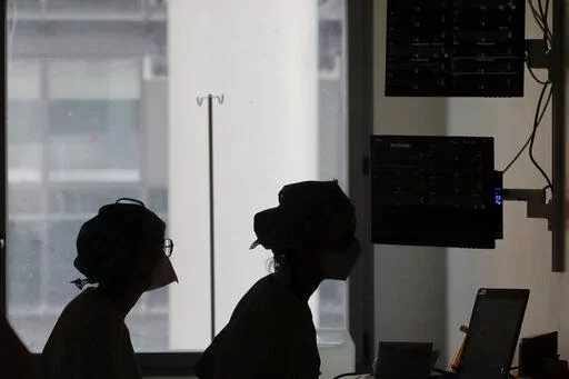 Nurses look at a screen near rooms with patients suffering from COVID-19, in the ICU unit at the Charles Nicolle public hospital, in Rouen, France, April 15, 2021. France is rolling out a new rule that will allow health workers who are infected with the coronavirus but have few or no symptoms to keep treating patients rather than self-isolate. The extraordinary stop-gap measure is an attempt to address staff shortages at hospitals caused by an unprecedented explosion in virus infections. (AP Pho