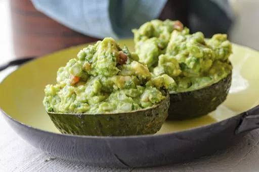 A recipe for guacamole, served in an avocado shell, appears in New York in June 2019. (Carrie Crow via AP)