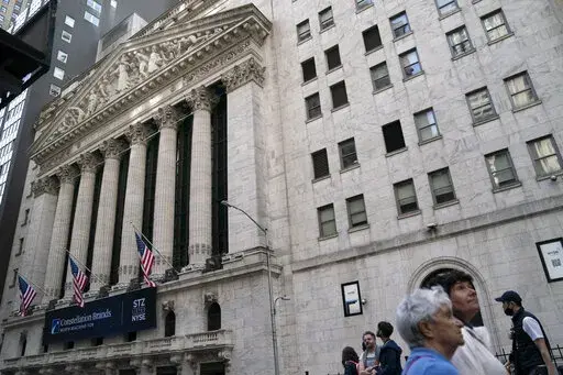 Pedestrians pass the New York Stock Exchange, Thursday, May 5, 2022, in the Manhattan borough of New York.  Stocks are opening lower and bond yields are rising as yet another report of robust hiring suggests the Federal Reserve will need to keep pressing the fight against inflation and cool off the economy with higher interest rates.  (AP Photo/John Minchillo)