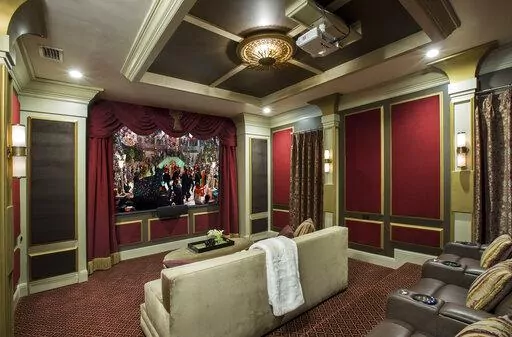 This image provided by John McClain Design shows a home theater with red velvet on the wall panels. The 'champagne-hued velvet' is on the big couch in foreground. For an Orlando, FL project, designer John McClain and his client wanted to evoke an Art Deco aesthetic, yet still design a functional state-of-the-art home theater. "We upholstered portions of the walls with red velvet inside of wooden accent panels to gain the hard-to-soft-surface-ratio that would normally be accomplished with acousti
