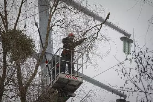 Workers of the electricity supply company DTEK maintain power lines by cutting off excess branches in Kyiv, Ukraine, Thursday, Dec. 8, 2022. Ukrainian utility crews struggling to patch up power lines during a two-month Russian military blitz targeting Ukrainian infrastructure are learning to adapt. And just as on the battlefield, Ukrainians are learning to respond quickly on the new energy front drawn inside homes, hospitals, offices, and schools in yet another act of defiance against a powerful