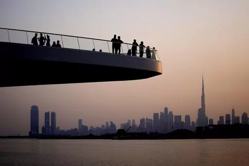 People stand on the observation deck of the Dubai Creek Harbour in Dubai, United Arab Emirates, Sunday, June 18, 2023, to view the city skyline with the world's tallest tower, the Burj Khalifa. Dubai hosts the United Nations COP28 climate talks starting Nov. 30. (AP Photo/Kamran Jebreili, File)