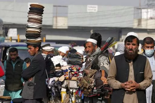 Street vendors wait for customers along a road in old area of Peshawar, Pakistan, Wednesday, Feb. 1, 2023. Peshawar, a key mountain valley connecting South and Central Asia, was once known as "the city of flowers," surrounded by orchards of pear, quince, and pomegranate trees. But for the past four decades, it has borne the brunt of rising militancy in the region, fueled by the conflicts in neighboring Afghanistan. (AP Photo/Muhammad Sajjad)