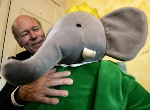 Babar author Laurent de Brunhoff poses for a photograph with Babar while celebrating 75 years of the book on Friday, April 21, 2006 at Mabel's Fables in Toronto, Ontario, Canada. De Brunhoff, a Paris native who moved to the U.S. in the 1980s, died Friday, March 22, 2024 at his home in Key West, Fla., according to The New York Times. (Nathan Denette /The Canadian Press via AP)