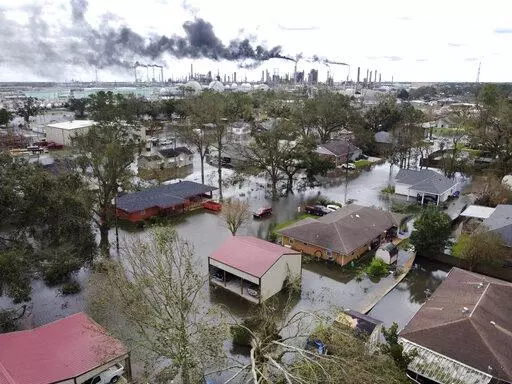 Homes near Norco, La., are surrounded by floodwater as refineries continue to flare the day after Hurricane Ida hit southern Louisiana, Aug. 30, 2021. Environmental and climate justice advocates from across the United States are decrying the court's 6-3 ruling on Thursday, June 30, 2022, saying it will be felt most by communities of color and poor communities, which are located near power plants at higher percentages than the national average. (Chris Granger/The Times-Picayune/The New Orleans Ad