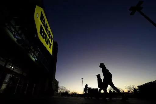 Shoppers are silhouetted against the sky as they arrives for a sale at a Best Buy store Friday, Nov. 25, 2022, in Overland Park, Kan. On Friday the Commerce Department issues its November report on consumer spending. The report contains a measure of inflation that is closely watched by the Federal Reserve, which has aggressively tried to corral inflation this year by raising its key lending rate seven times. (AP Photo/Charlie Riedel, File)