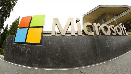 This July 3, 2014, file photo, shows the Microsoft Corp. logo outside the Microsoft Visitor Center in Redmond, Wash. Microsoft is cutting 10,000 workers, almost 5% of its workforce, in response to “macroeconomic conditions and changing customer priorities.”The company said in a regulatory filing Wednesday, Jan. 18, 2023 that had just notified employees of the layoffs, some of which begin immediately.The company said it will also be making changes to its hardware portfolio and consolidating i