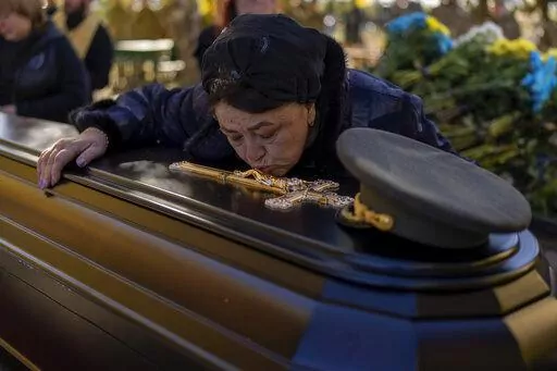 Tatiana Alexeyevna mourns over the coffin of her son Colonel Oleksiy Telizhenko during his funeral in Bucha, near Kyiv, Ukraine, Tuesday, Oct. 18, 2022. In March, Colonel Oleksiy was abducted by Russian soldiers from his home in Bucha, six months later his body was found with signals of torture buried in a forest not far away from his village. (AP Photo/Emilio Morenatti)