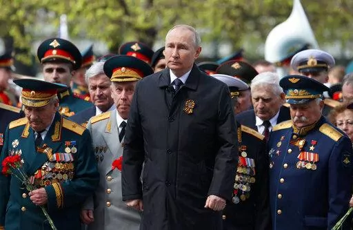 Russian President Vladimir Putin, centre, attends a wreath-laying ceremony at the Tomb of the Unknown Soldier after the military parade marking the 77th anniversary of the end of World War II, in Moscow, Russia, Monday, May 9, 2022. (Anton Novoderezhkin, Sputnik, Kremlin Pool Photo via AP)