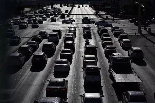 Cars wait at a red light during rush hour, April 22, 2021, in Las Vegas. Motor vehicles with higher, more vertical front ends are the most dangerous to pedestrians, according to a highway safety organization. (AP Photo/John Locher, File)