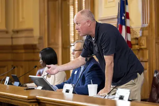 State Election Board member Rick Jeffares asks the crowd to settle down during a hastily planned State Election Board meeting at the Capitol in Atlanta, July 12, 2024. (Arvin Temkar/Atlanta Journal-Constitution via AP, File)/
