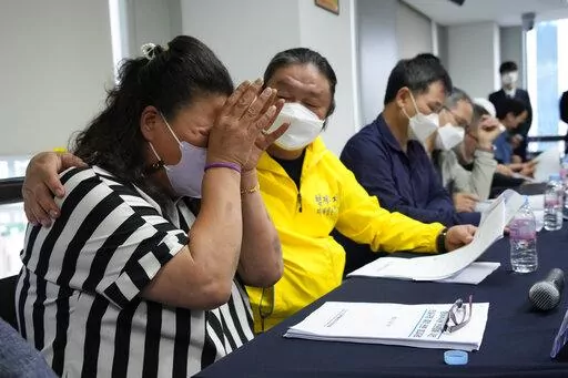 Park Sun-yi, left, a victim of Brothers Home, weeps during a press conference at the Truth and Reconciliation Commission office in Seoul, South Korea, Wednesday, Aug. 24, 2022. The commission has found the country's past military governments responsible for atrocities committed at Brothers Home, a state-funded vagrants' facility where thousands were enslaved and abused from the 1960s to 1980s. (AP Photo/Ahn Young-joon)