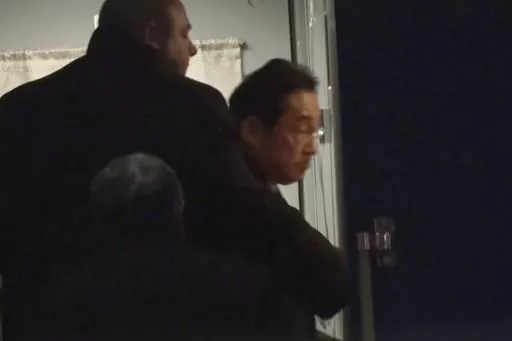 In this image made from video provided by Japan's NTV, Japanese Prime Minister Fumio Kishida gets on train in Przemysl, Poland, early Tuesday, March 21, 2023, heading to Kyiv for talks with Ukrainian President Volodymyr Zelenskyy. Kishida’s surprise trip to Ukraine comes just hours after he met with Indian Prime Minister Narendra Modi in New Delhi. (NTV via AP)
