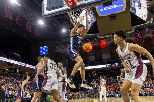 Virginia forward Kadin Shedrick (21) hangs from the basket after a dunk during the second half against Mississippi State in an NCAA college basketball game in the first round of the NIT, Wednesday, March 16, 2022, in Charlottesville, Va. (Erin Edgerton/The Daily Progress via AP)