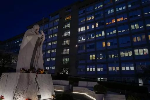 A statue of late Pope St. John Paul II is backdropped by the Agostino Gemelli hospital in Rome, Wednesday, March 29, 2023, after The Vatican said Pope Francis has been taken there in the afternoon for some scheduled tests. The Vatican provided no details, including how long the 86-year-old pope would remain at Gemelli University Hospital, where he underwent surgery in 2021. But his audiences through Friday were canceled, raising questions about Francis' participation during the Vatican's Holy We