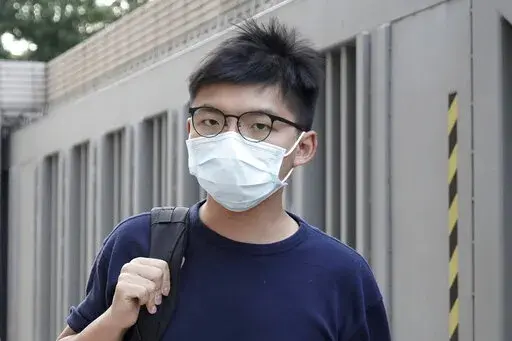 Pro-democracy activist Joshua Wong, right, arrives at a court in Hong Kong on Oct. 15, 2020. Authorities in Hong Kong say 29 out of 47 pro-democracy activists charged with “conspiracy to commit subversion” under a tough National Security Law have pleaded guilty, as the Beijing government seeks to further silence opposition voices in the regional financial hub. (AP Photo/Kin Cheung, File)