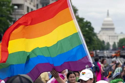 With the U.S. Capitol in the background, a person waves a rainbow flag as they participant in a rally in support of the LGBTQIA+ community at Freedom Plaza, Saturday, June 12, 2021, in Washington. The U.S. House overwhelmingly approved legislation Tuesday, July, 19, 2022, to protect same-sex and interracial marriages amid concerns that the Supreme Court ruling overturning Roe v. Wade abortion access could jeopardize other rights criticized by many conservative Americans. (AP Photo/Jose Luis Maga