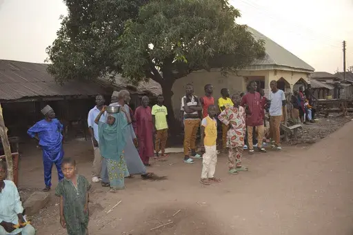 People gather around an area were gunmen kidnapped school children in Chikun, Nigeria, Thursday, March 7, 2024. Gunmen attacked a school in Nigeria's northwest region Thursday morning and abducted at least 287 students, the headteacher told authorities, marking the second mass abduction in the West African nation in less than a week. (AP Photo)