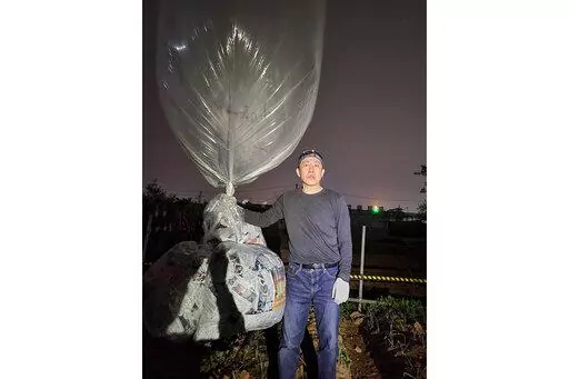 Park Sang-hak, a North Korean defector-turned-activist, prepares to release a balloon bearing leaflets at the border town of Gimpo, South Korea, on April 25, 2022. The South Korean activist said Thursday, April 28, he launched a million propaganda leaflets by balloon into North Korea this week, in his first such campaign while standing trial for past leafleting under a contentious new law that criminalizes such actions.(Courtesy of Fighters For A Free North Korea via AP)