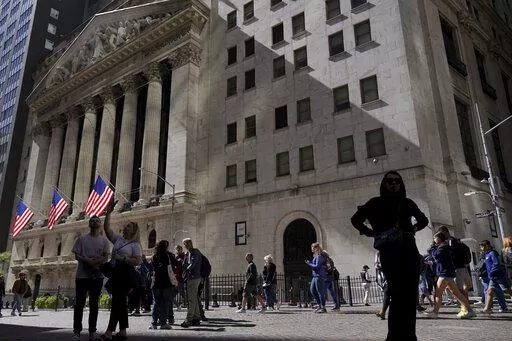 Visitors to the financial district walk past the New York Stock Exchange, Friday, Sept. 23, 2022, in New York. After sweeping through battles in statehouses across the country, the war against what's called ESG investing is heating up in Congress. (AP Photo/Mary Altaffer, File)