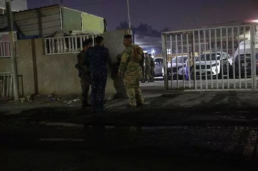 Iraqi security forces gather outside a morgue of Sheikh Zayed Hospital in Baghdad, Monday, Nov. 7, 2022. Assailants shot dead an American aid worker in Baghdad on Monday in a rare killing of a foreigner in the Iraqi capital in recent years, two police officials said. (AP Photo/Hadi Mizban)