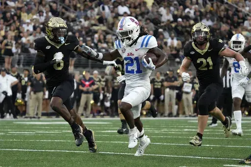 Mississippi running back Henry Parrish Jr. (21) runs for a touchdown against Wake Forest defensive back Rushaun Tongue (6) during the first half of an NCAA college football game in Winston-Salem, N.C., Saturday, Sept. 14, 2024. (AP Photo/Chuck Burton)