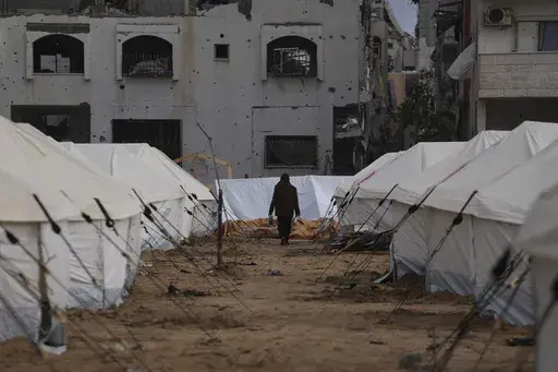 A man walks between tents for displaced Palestinians next to destroyed buildings following the Israeli air and ground offensive in Jabaliya, Gaza Strip, Thursday, Feb. 6, 2025. (AP Photo/Abdel Kareem Hana, file)