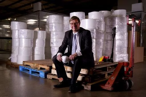 Jim Schmersahl, owner of Halcyon Shades, poses with material used in making N-95 masks Friday, March 18, 2022, in University City, Mo. Halcyon is small company that normally makes window shades, but when the pandemic hit, its sales plummeted. Halcyon applied for the state grants to make PPE as a way to try to keep its employees at work and keep the company afloat. (AP Photo/Jeff Roberson)