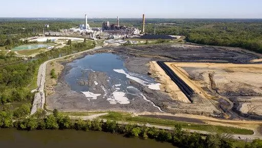 In this May 1, 2018, file photo, the Richmond, Va., city skyline is seen in the horizon behind the coal ash ponds along the James River near Dominion Energy's Chesterfield Power Station in Chester, Va. In the first first major action to address toxic wastewater from coal-burning power plants, the Environmental Protection Agency is denying requests by three Midwest power plants to extend operations of leaking or otherwise dangerous coal ash storage ponds. (AP Photo/Steve Helber, File)