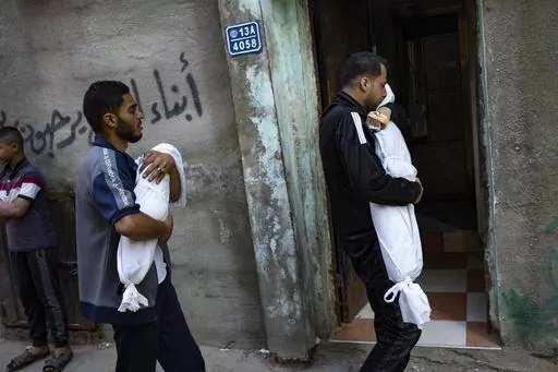 Members of the Abu Draz family hold the bodies of their relatives killed in the Israeli bombardment of the Gaza Strip, at their house in Rafah, southern Gaza, Thursday, April 4, 2024. (AP Photo/Fatima Shbair)