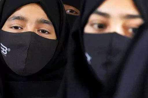 Indian Muslim students wearing hijabs and face masks gather to meet student activists in Kundapur in district Udupi, Karnataka state, India, Saturday, Feb. 26, 2022. An Indian court ruling upholding a ban on Muslim students wearing head coverings in schools has sparked criticism from constitutional scholars and rights advocates amid concerns of judicial overreach regarding religious freedoms. (AP Photo/Aijaz Rahi)