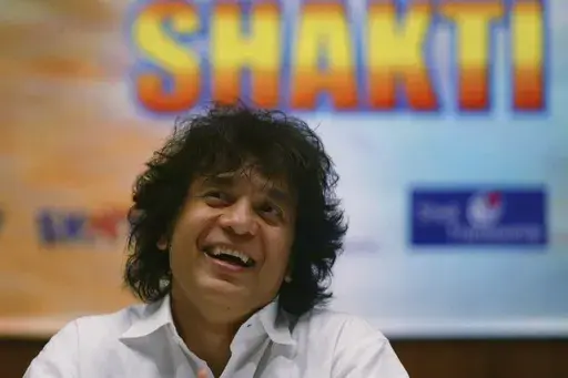 Indian Tabla expert Zakir Hussain laughs during a press conference to announce a musical concert in Mumbai, India, on Dec 8, 2006. (AP Photo/Rajesh Nirgude, File)