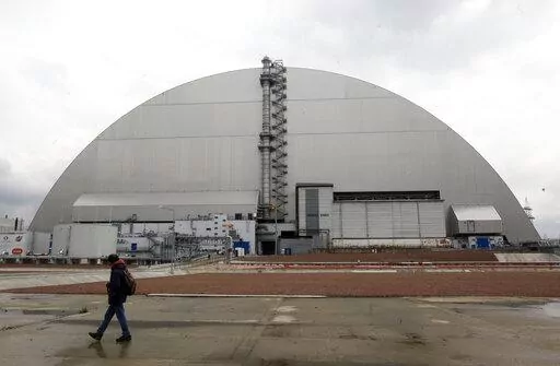 A man walks past a shelter covering the exploded reactor at the Chernobyl nuclear plant, in Chernobyl, Ukraine, Thursday, April 15, 2021. When fighting from Russia’s invasion of Ukraine resulted in power cuts to the critical cooling system at the closed Chernobyl nuclear power plant, some feared that spent nuclear fuel would overheat. But nuclear experts say there’s no imminent danger because time and physics are on safety's side. (AP Photo/Efrem Lukatsky, File)
