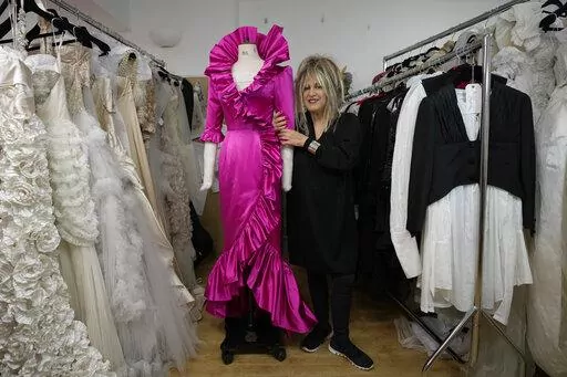 British designer Elizabeth Emanuel stands beside a replica of an evening gown she designed for the then Lady Diana Spencer to wear at a Buckingham Palace party a few days before her marriage to Prince Charles in 1981, in London, Friday, Nov. 18, 2022. Emanuel recreated the dress for her own archive and to show another side of Diana, who Emanuel believes has been misrepresented by "The Crown," the popular Netflix series that has brought the story of the princess and her ill-fated marriage to a ne