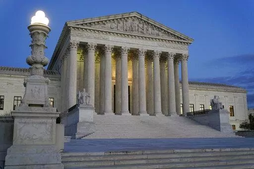 Light illuminates part of the Supreme Court building at dusk on Capitol Hill in Washington, Nov. 16, 2022. The court is set to hear arguments Wednesday in a case from North Carolina, where Republican efforts to draw congressional districts heavily in their favor were blocked by a Democratic majority on the state Supreme Court because the GOP map violated the state constitution. (AP Photo/Patrick Semansky, File)