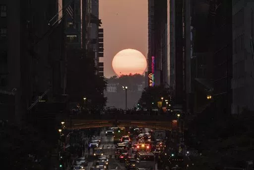 The sun sets between buildings along 42nd Street in New York during a phenomenon known as "Manhattanhenge," May 30, 2023. Twice per year, New Yorkers and visitors are treated to a phenomenon known as Manhattanhenge, when the setting sun aligns with the Manhattan street grid and sinks below the horizon framed in a canyon of skyscrapers. Manhattanhenge happens for the first time this year on Tuesday, May 28, at 8:13 p.m. and Wednesday, May 29, at 8:12 p.m. (AP Photo/Yuki Iwamura, File)