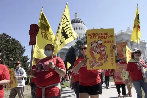 Fast food workers and their supporters march past the California state Capitol in Sacramento, Tuesday, Aug. 16, 2022. California Gov. Gavin Newsom and legislative leaders have agreed to restore funding to the Industrial Welfare Commission, which has the power to regulate wages, hours and working conditions in California. Business groups oppose restoring the commission. A law that would create a similar commission to regulate the fast food industry passed last year but has been put on hold pendin