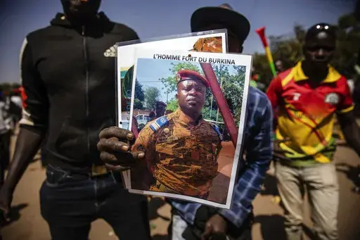 A man holds a portrait of Lt. Col. Paul Henri Sandaogo Damiba who has taken the reins of Burkina Faso, in Ouagadougou, Jan. 25, 2022. Attacks by Islamic extremists are on the rise five months after mutinous soldiers overthrew Burkina Faso's democratically elected president in January. And analysts say that could undermine support for Damiba's regime. Writing on portrait reads in French "The strong man of Burkina".  (AP Photo/Sophie Garcia, File)