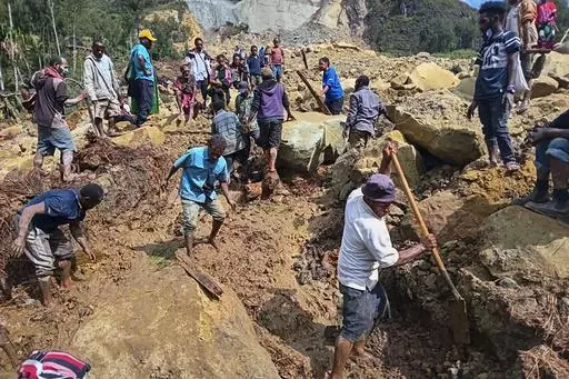 CORRECTS TO YAMBALI FOR LOCATION, NOT POGERA - Villagers search through a landslide in Yambali, in the Highlands of Papua New Guinea, Sunday, May 26, 2024. The International Organization for Migration feared Sunday the death toll from a massive landslide is much worse than what authorities initially estimated. (Mohamud Omer/International Organization for Migration via AP)