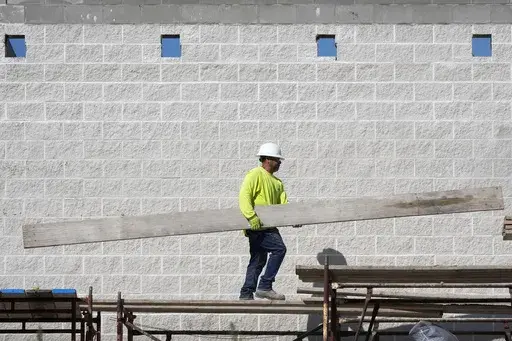 A construction worker walks on scaffolding at a building site on Sept. 4, 2024, in Waukee, Iowa. (AP Photo/Charlie Neibergall, File)