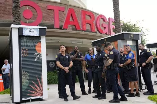 Police officers stand outside of a Target store as a group of people across the street protest against Pride displays in the store on June 1, 2023, in Miami. Target confirmed that it won't be carrying its LGBTQ+ merchandise for Pride month in June, 2024, in some stores after the discount retailer received backlash last year for its assortment. (AP Photo/Lynne Sladky, File)