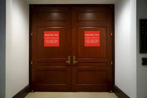 Bright red signs alert non-authorized personnel at the entrance to the House SCIF, the Sensitive Compartmented Information Facility, located three levels beneath the Capitol where witnesses and lawmakers hold closed interviews in the impeachment inquiry on President Donald Trump's efforts to press Ukraine to investigate his political rivals, in Washington, Nov. 6, 2019. When members of Congress want to peruse classified materials, they descend deep into the basement of the Capitol to a sensitive