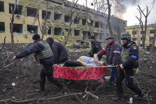 FILE- Iryna Kalinina, 32, an injured pregnant woman, is carried from a maternity hospital that was damaged during a Russian airstrike in Mariupol, Ukraine, on 9 March 2022. Associated Press photographer Evgeniy Maloletka won the World Press Photo of the Year award on Thursday, April 20, 2023, for this harrowing image of emergency workers carrying a pregnant woman through the shattered grounds of a maternity hospital in the Ukrainian city of Mariupol in the chaotic aftermath of a Russian attack. 