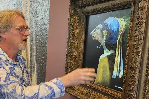 Rob de Heer talks next to his artwork, one of 60 pieces exhibited and inspired by the famous "Girl with a Pearl Earring," painting by Johannes Vermeer, at The Mauritshuis museum in The Hague, Netherlands, Tuesday, March 25, 2025. (AP Photo/Molly Quell)
