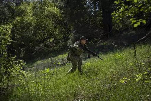 A Ukrainian Border Guard soldier participates in a military exercise in central Ukraine, Monday, May 1, 2023. Ahead of the much-anticipated Ukrainian counter-offensive, newly formed military assault units train in the country's dense forests. (AP Photo/Bernat Armangue)
