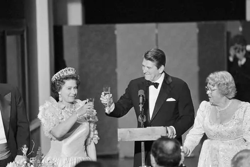 President Ronald Reagan and Queen Elizabeth II raise their glasses in a toast during a state dinner, March 3, 1983, at the M. H. de Young Museum in San Francisco's Golden Gate Park. Woman at right is unidentified. The FBI has disclosed a potential threat to the late Queen Elizabeth during her 1983 trip to the U.S. West Coast. The documents were released this last week of May, 2023, on the FBI’s records website. (AP Photo/Ed Reinke, File)